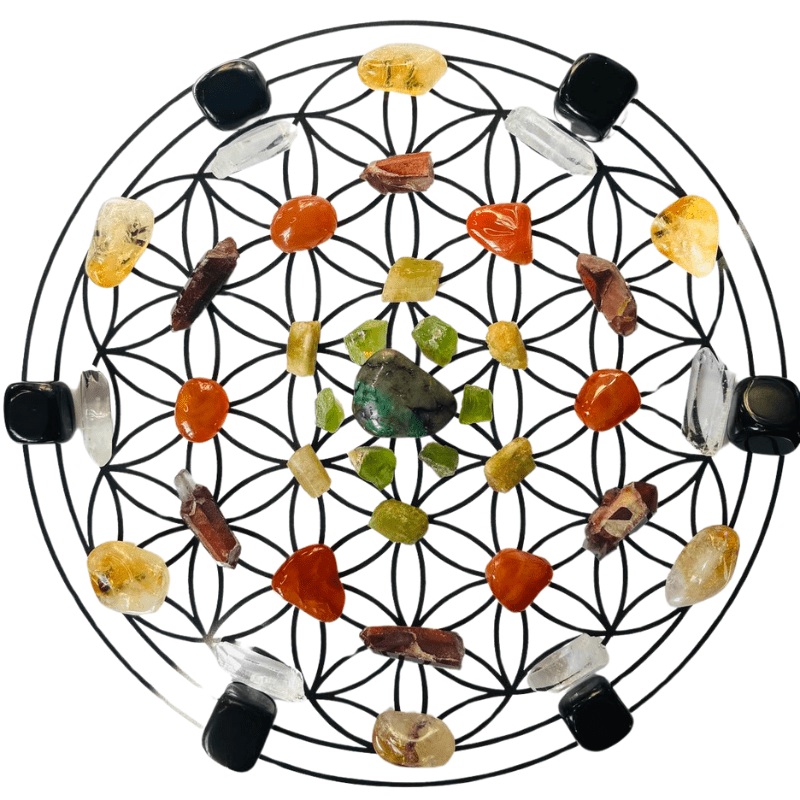 Crystal grid in a Flower of Life layout featuring a central Emerald, surrounded by layers of Peridot, Yellow Apatite, Carnelian, Red Jasper, Citrine, Clear Quartz, and Black Obsidian.